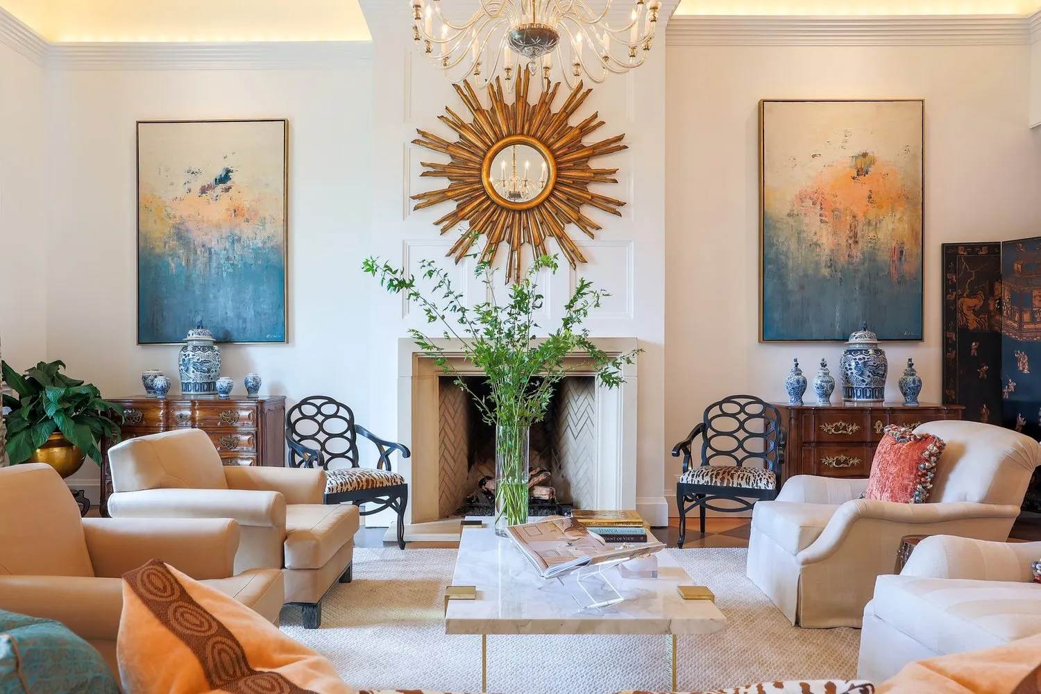 A living room on the river in Chattanooga, a gilt sunburst mirror over the fireplace and blue-and-white porcelain on the flanking chests.